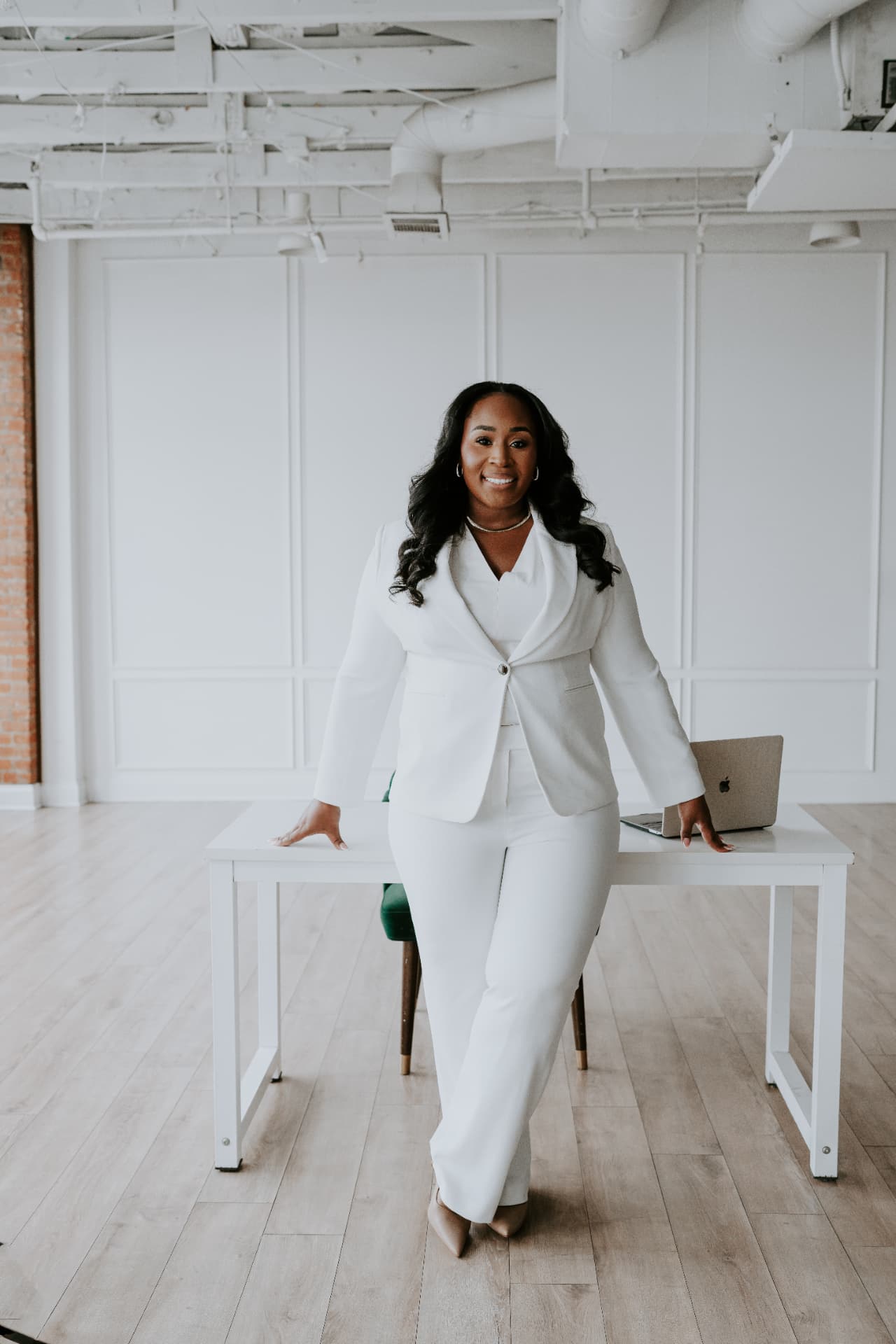 Jennifer Allen, The Wedding Auntie, standing at a table in a white suit